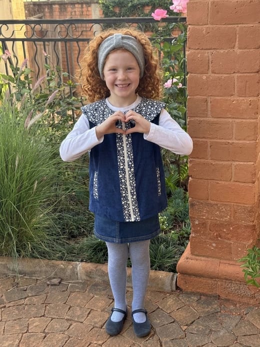 Fillette portant le gilet Lova en velours bleu